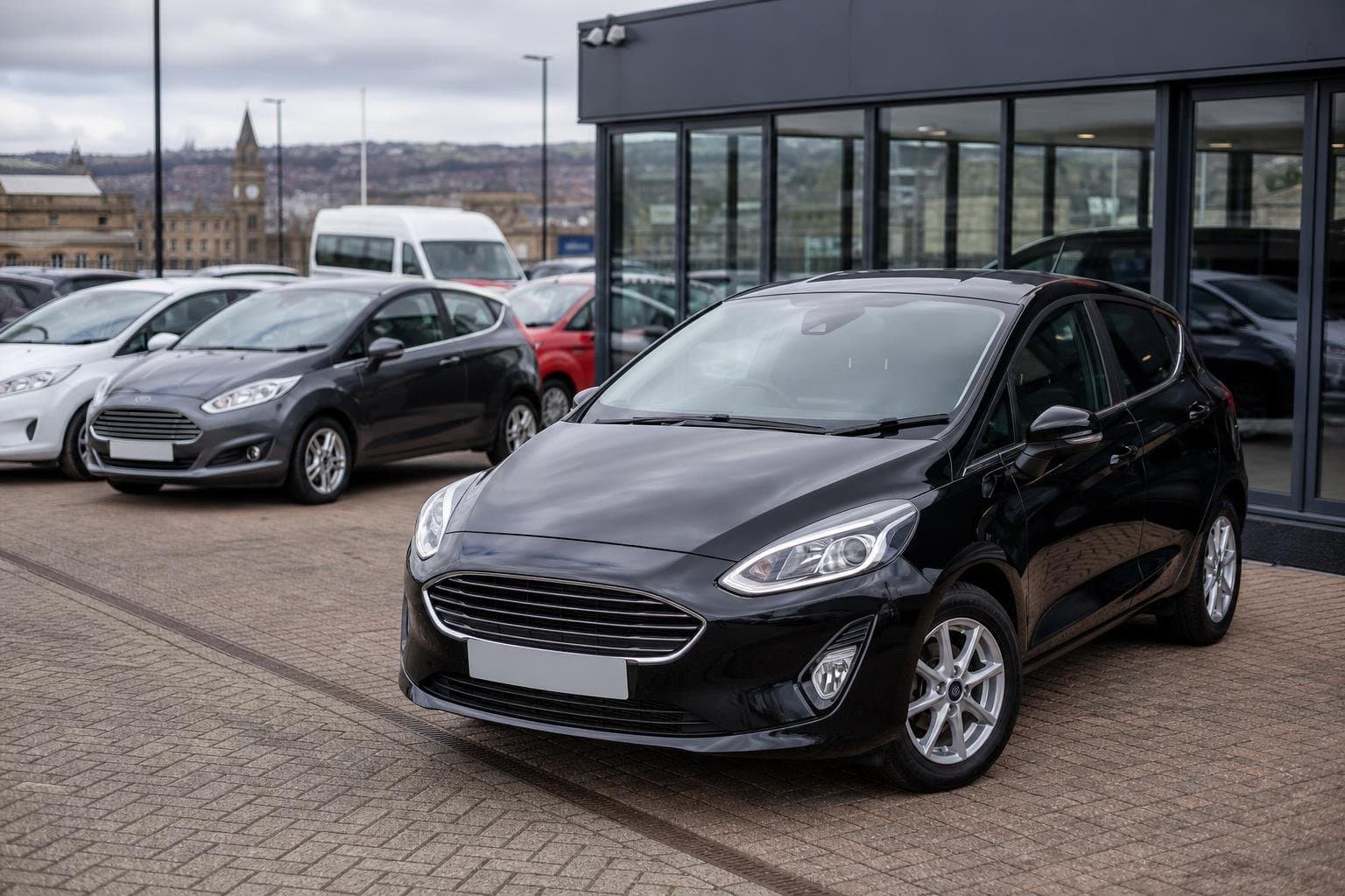 Compact hire cars lined up outside a modern vehicle hire branch in Bradford
